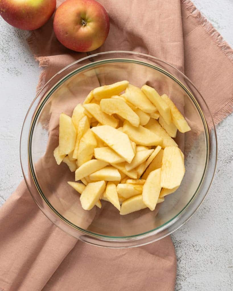 Apples peeled and sliced in a bowl.