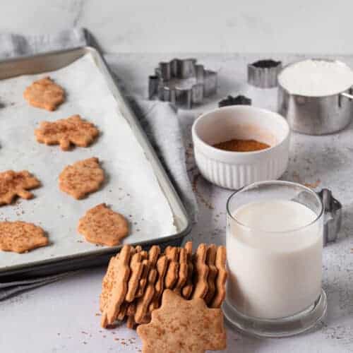 Cinnamon cookies next to a glass with milk.