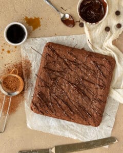 Overhead photo of crème de cacao brownies topped with melted chocolate and flaky sea salt.