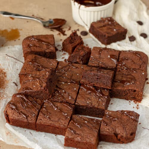 Photo of sliced crème de cacao brownies placed in different spots on top of parchment paper.