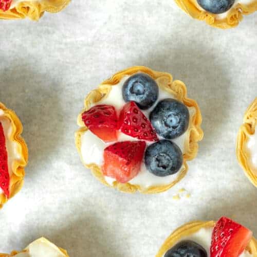 Overhead shot of phyllo cup filled with Greek yogurt and topped with fresh strawberries and blueberries.