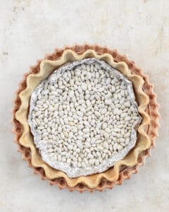 Line the crust with aluminum foil and fill with pie weights or beans.