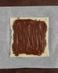 Photo of puff pastry sheet with hazelnut spread.