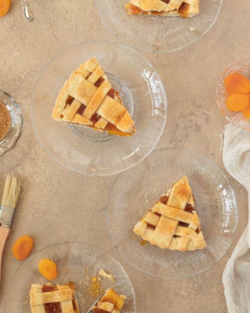 Overhead photo of sliced apricot jam tart served in glass plates.