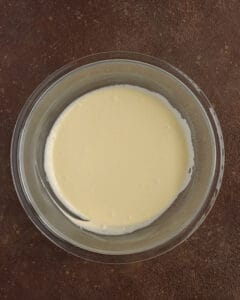 Photo of egg yolks, powdered sugar and mascarpone cheese mixed in a bowl.