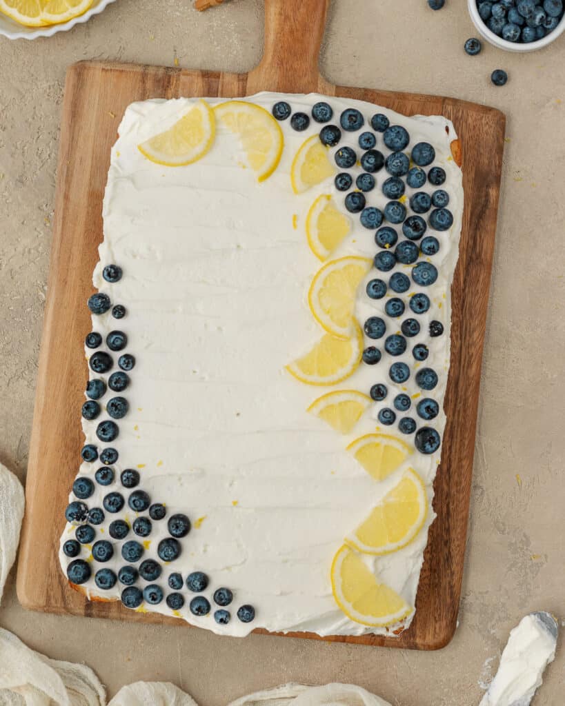 Overhead photo of the frosted blueberry lemon sheet cake topped with blueberries and lemon slices.