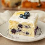 Photo of blueberry lemon sheet cake slice on a dessert plate.