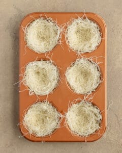 Photo of the kataifi dough inside the muffin pan before baking.