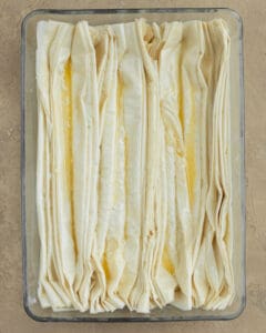 Photo of the buttered phyllo layers placed horizontally in the baking pan.