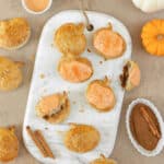 Overhead photo of puff pastry pumpkin pop tarts on a white marble board